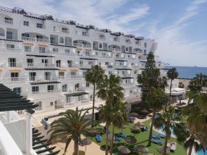 a large white hotel with palm trees and the ocean at Bahía Serena in Roquetas de Mar