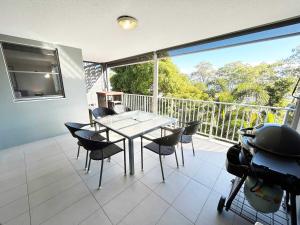 een eetkamer met een tafel en stoelen op een balkon bij Bribie Sunset Vistas in Bongaree