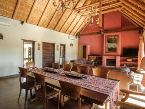 Un comedor con una mesa grande y sillas. en Kokobela Lodge, en Phalaborwa