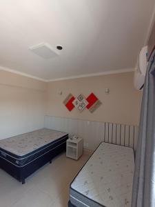 dwa łóżka w małym pokoju z plakatami na ścianie w obiekcie Caldas Novas - diRoma Spazzio - Apto até 4 pessoas - piscinas do hotel 24 horas w mieście Caldas Novas