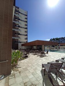 patio ze stołami i krzesłami oraz budynek w obiekcie Caldas Novas - diRoma Spazzio - Apto até 4 pessoas - piscinas do hotel 24 horas w mieście Caldas Novas