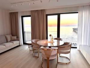 a living room with a table and a view of the ocean at Baltic Infinity Resort&Spa Apartament Dworek in Międzyzdroje