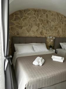 Dos toallas en una cama con dos almohadas. en Al Fiko Suite, en Catania