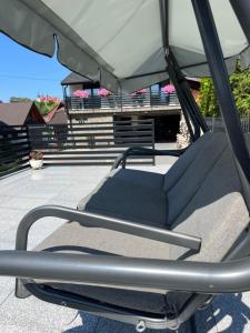 a swing seat in an umbrella on a patio at Apartamenty pod Stokiem in Kluszkowce
