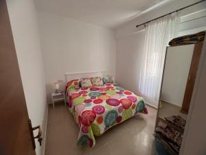 a bedroom with a bed with a colorful comforter at Ventana al mar in Tangier