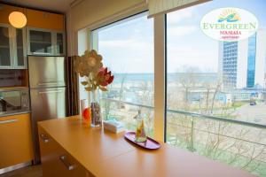 a kitchen with a counter and a large window at Evergreen Vlas Mamaia Sud in Mamaia