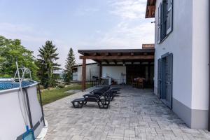 a group of benches sitting on a patio next to a building at Villa Katalea - piscina privata e barbecue in Asti