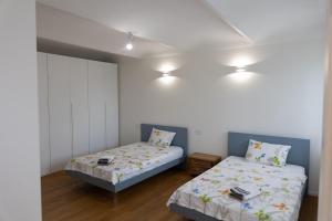 two beds in a room with white walls and lights at Villa Katalea - piscina privata e barbecue in Asti +47 photos