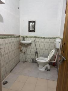 a bathroom with a toilet and a sink at Sunshine Homestay in Bhowāli