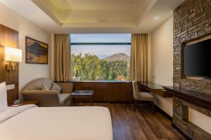 a hotel room with a bed and a large window at Radisson Srinagar in Srinagar