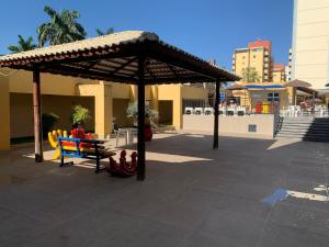 a pavilion with chairs under a roof on a patio at Eldorado Flat Service Host Hub | Localização Top em frente ao Clube Privé in Caldas Novas