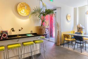 a restaurant with yellow bar stools and a table at Accueil Hôtel Paris Pigalle Montmartre - Hôtel rénové in Paris