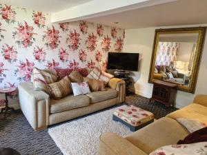 a living room with a couch and a mirror at Cosy cottage at rustic escapes 