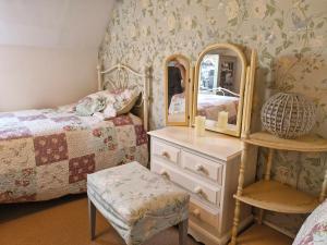 a bedroom with a bed and a dresser and a mirror at Cosy cottage at rustic escapes 