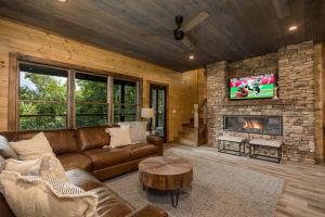 Una sala de estar con un sofá y una chimenea. en Smoky Sunrise, en Sevierville