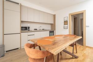 a kitchen with a wooden table and chairs at Autentica Apart in Cetinje