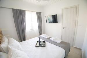 a hotel room with a bed with a tray on it at Dolce Far Niente Greece in Agioi Theodoroi