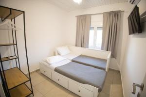 a small bedroom with a bed and a window at Dolce Far Niente Greece in Agioi Theodoroi