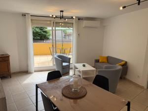 a living room with a table and a couch at Le Sudiste in La Ciotat
