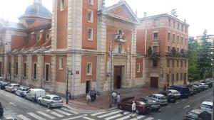 un gran edificio con coches estacionados frente a él en Pensión Calfred II, en Logroño