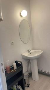 Un baño con un lavabo y un espejo en la pared. en Meaux Centre 2 Vue cathédrale, en Meaux