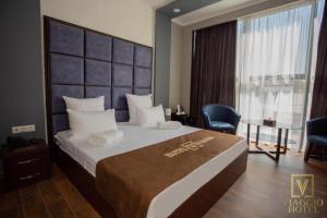 una camera d'albergo con un letto grande e una finestra di VIAGGIO Hotel BY VG a Yerevan