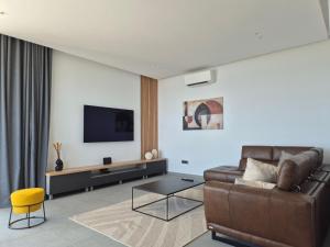 a living room with a couch and a flat screen tv at Villa Marmonte, Luksuzna vila s bazenom i pogledom na more in Medveja