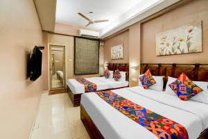 a hotel room with two beds and a television at FabHotel Arastu Plaza - Nr Nampally Railway Station in Hyderabad