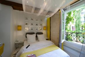une petite chambre avec un lit et une fenêtre dans l'établissement Les Patios du Marais 2, à Paris
