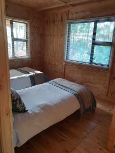 two beds in a log cabin with two windows at Sielerus in The Crags