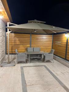 un tavolo e due sedie sotto un ombrellone su un patio di VIAGGIO Hotel BY VG a Yerevan