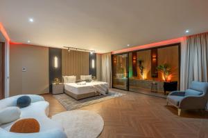 a bedroom with a bed and a couch and a chair at Villa Mareva & Spa Marrakech in Marrakesh