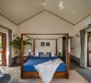Un dormitorio con una cama grande con un edredón azul. en Fable by RÊVE, en Assagao