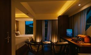 una camera d'albergo con un letto e una scrivania con una televisione di Hanoi Amsterdam Art Studio a Da Lat