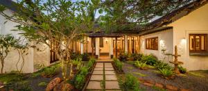 a house with a pathway leading to the front yard at Fable by RÊVE Escapes - Premium 3 BHK Villa Near Vagator Beach in Assagao