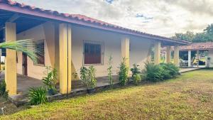 une maison avec des colonnes jaunes et une cour dans l'établissement Casa Pamplona, à Soure