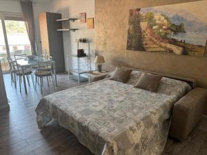 Un dormitorio con una cama y un comedor. en Luxury Green Apartment, en Milazzo