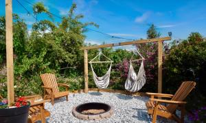 a patio with two chairs and a fire pit at Stylish 2 Bedroom Cottage with Hot Tub and Parking in Bewdley