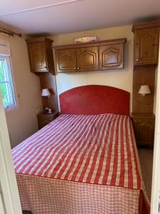 Dormitorio pequeño con cama con colcha a rayas en Mobil-Home Vue Mer 4 personnes, en Saint-Cast-le-Guildo