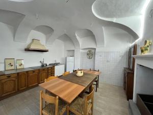 a kitchen with a wooden table and some chairs at Cascina Zanta in Valdengo