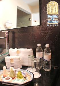 una mesa con una bandeja de comida y botellas de agua en Hotel Puebla de Antaño, en Puebla