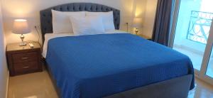 a bedroom with a blue bed with a blue comforter at Sharm hills sea view in Sharm El Sheikh +81 photos