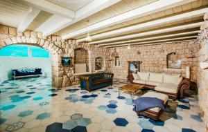 ein Wohnzimmer mit einer Steinwand mit einem Sofa und Tischen in der Unterkunft Villa G Imotski-Makarska by Villas Guide in Imotski
