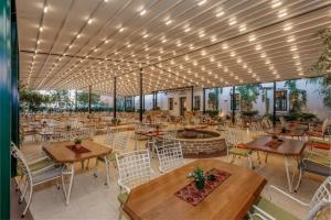 a restaurant with tables and chairs and a fire pit at Hotel Zavicaj in Belgrade