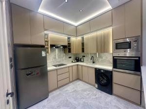 a kitchen with a refrigerator and a dishwasher at نزل الشمس in Jeddah