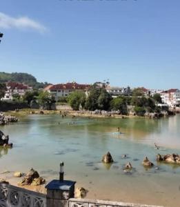 Un río con un grupo de personas en el agua en LA Escollera II Noja, en Noja