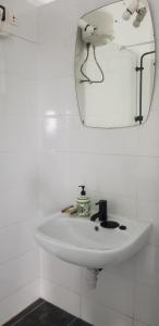 a white sink in a bathroom with a mirror at La croix du sud in Lomé