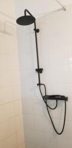 a shower in a bathroom with a black rack on the wall at La croix du sud in Lomé