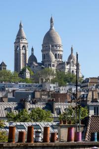 a view of the roofs of the city at Accueil Hôtel Paris Pigalle Montmartre - Hôtel rénové in Paris