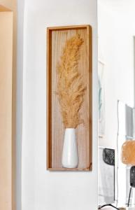 un vase blanc sur un mur avec un cadre en bois dans l'établissement Studio Rue Nationale, à Paris